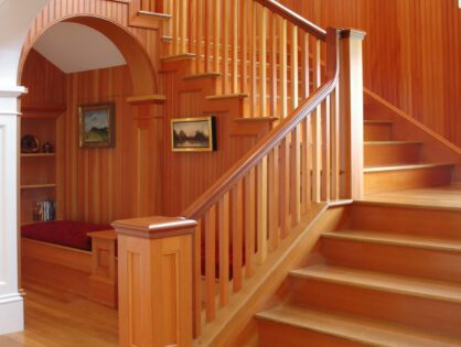 A wooden staircase with wood railing and steps.