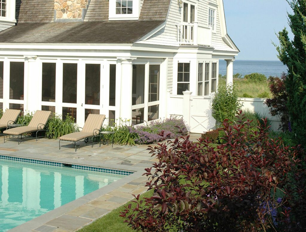 A house with a pool and a deck in the background.