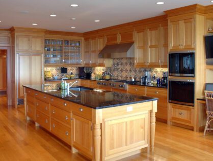 A large kitchen with wooden cabinets and black countertops.