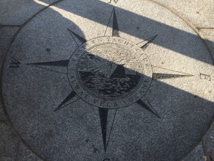 A compass rose on the ground with shadows.